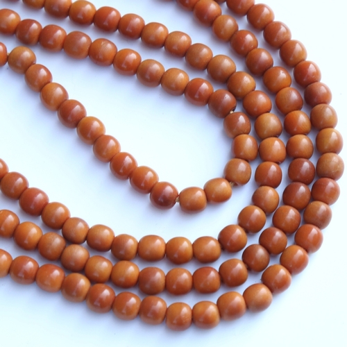 242 - A string of honey coloured natural horn beads, possibly rhino horn