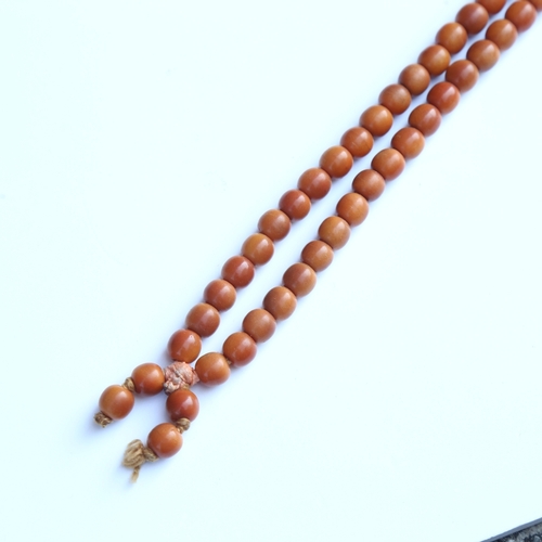 242 - A string of honey coloured natural horn beads, possibly rhino horn