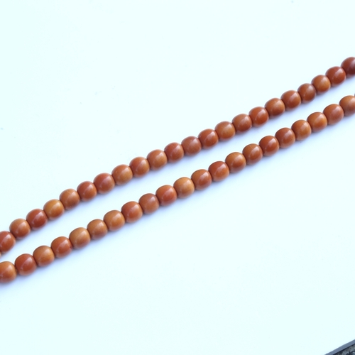 242 - A string of honey coloured natural horn beads, possibly rhino horn