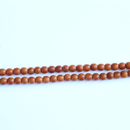 242 - A string of honey coloured natural horn beads, possibly rhino horn