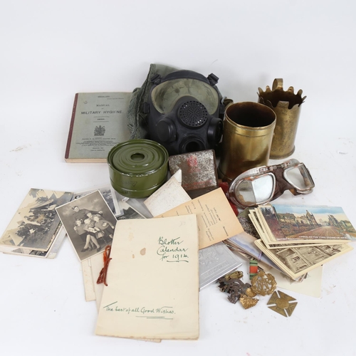 116 - Various military ephemera, including trench art cannon shell vases, cap badges, postcards etc (boxfu... 