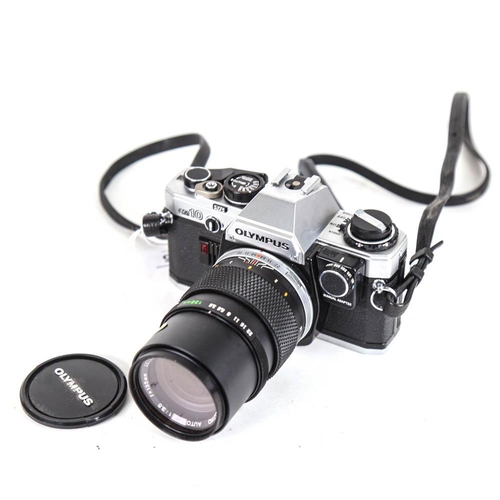 55 - OLYMPUS - a Vintage OM10 35mm single lens reflex camera, with Olympus 135mm 1:3.5 lens and Skylight ... 