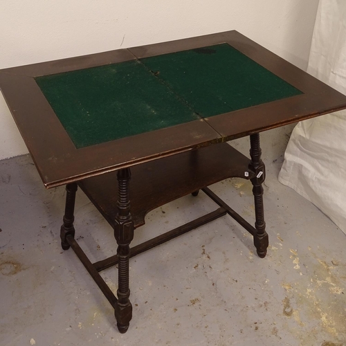 2443 - An Edwardian oak fold over card table, on a ring turned splayed leg base, W64cm, H74cm