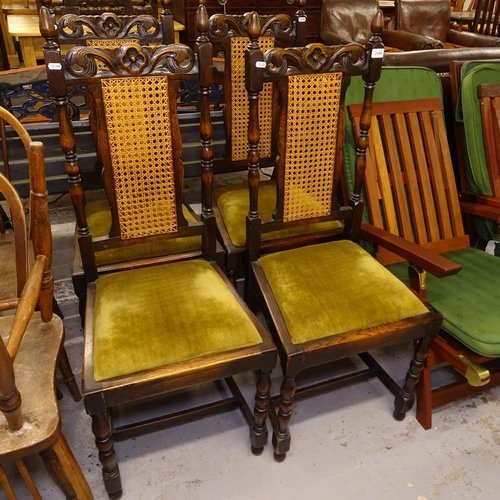 2448 - A set of 4 1920s oak dining chairs, with carved crests and caned panelled backs