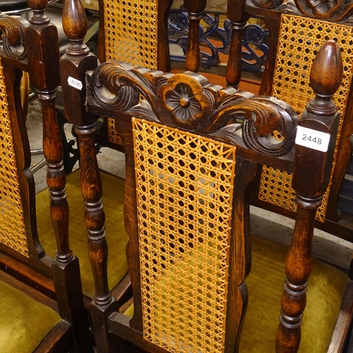 2448 - A set of 4 1920s oak dining chairs, with carved crests and caned panelled backs