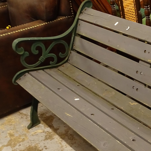 2457 - A green painted wrought-iron and slatted garden bench, L142cm