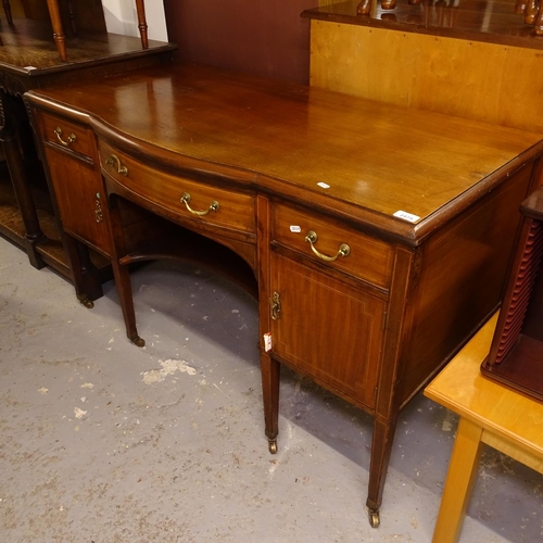 2479 - An Edwardian mahogany and satinwood-strung bow-front writing desk, with fitted drawers and cupboards... 