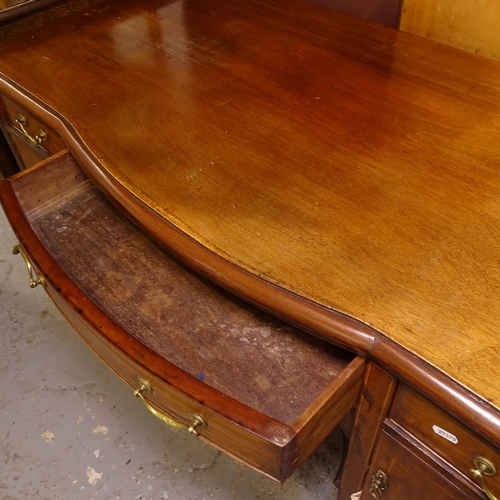 2479 - An Edwardian mahogany and satinwood-strung bow-front writing desk, with fitted drawers and cupboards... 