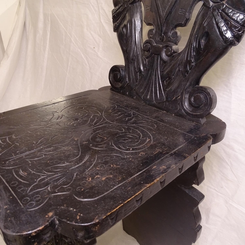 2484 - An Italian carved ebonised hall chair, with winged figural panelled back