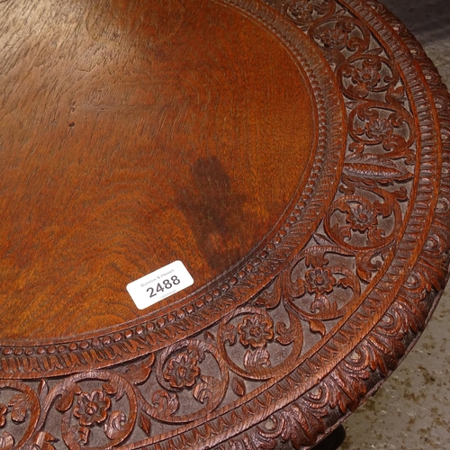 2488 - An Anglo-Indian hardwood lamp table, with allover relief carved decoration, and dragon design suppor... 