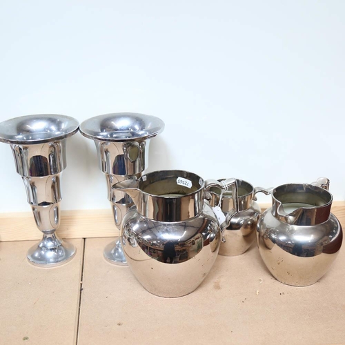 512 - A graduated set of silver lustre jugs, and a pair of metal vases, height 22cm