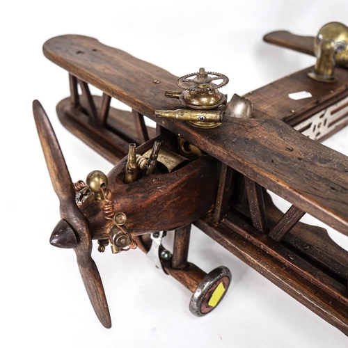 550 - A handmade wooden sculpture of a bi-plane, length overall 56cm, width 53cm