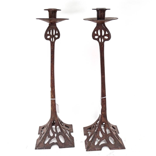 551 - A large pair of Arts and Crafts style wrought-iron candlesticks, height 50cm