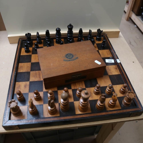 556 - A turned wood chess set and box, with games board, King height 10cm