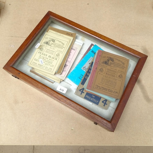 610 - A table-top display case, with a collection of brochures and stamp catalogues