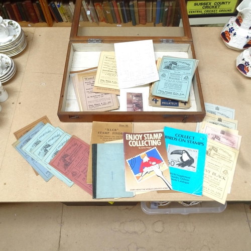 610 - A table-top display case, with a collection of brochures and stamp catalogues