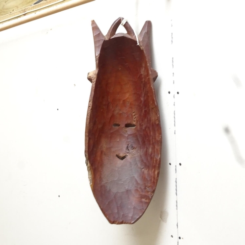 632 - A carved hardwood mask, 62cm