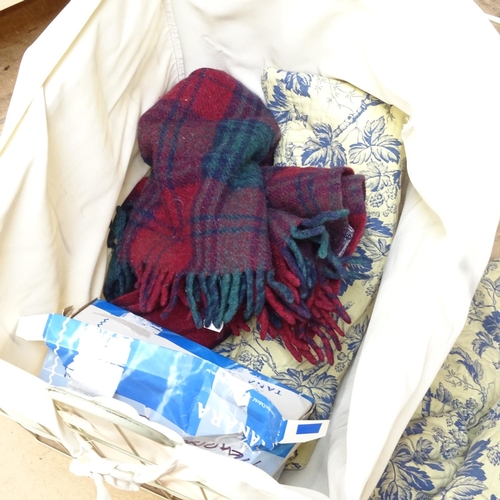 651 - A basket with quilt, picnic blanket etc