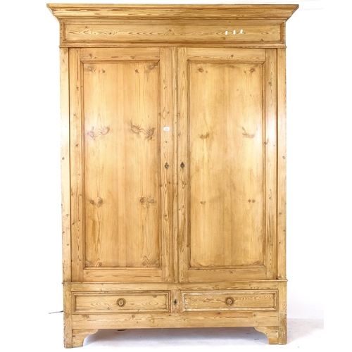 2058 - A Continental pine armoire, with a shelved interior, 2 panelled doors and drawers under, W160cm, H22... 