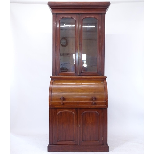 2070 - A 19th century mahogany cylinder-front bureau bookcase, sliding fitted interior, arched panelled doo... 