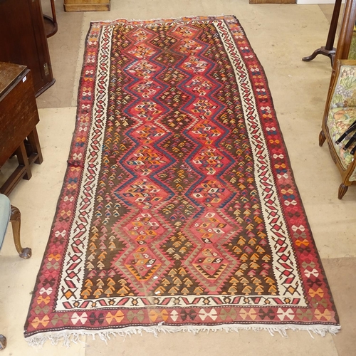 2100 - A large red ground Kilim carpet, 344cm x 154cm