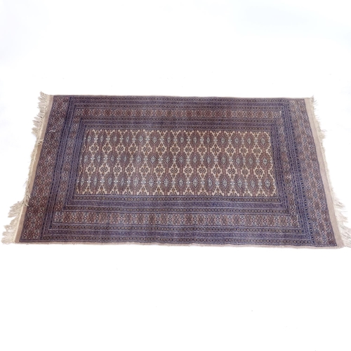 2104 - A beige ground Afghan design rug, 185cm x 120cm