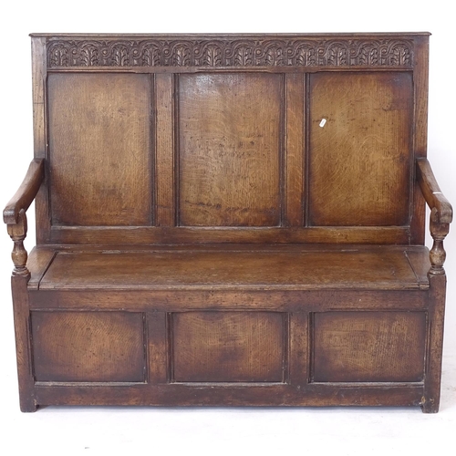 2116 - An early 20th century oak settle, with chip carved panelled raised back, on stile legs, hinged seat ... 