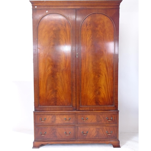 2123 - A mahogany 2-section wardrobe, with 2 arch-panelled doors, and a 4-drawer fitted base on bracket fee... 