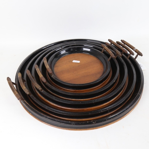 114 - A graduated set of 5 walnut and ebonised wood circular trays, sizes from 21cm to 42cm (5)