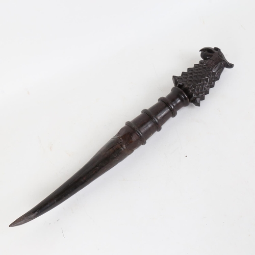 85 - An African horn-tipped implement, with carved phoenix handle, overall length 44cm