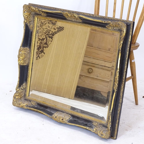 2151 - A decorative black and gilt-framed bevel-edge wall mirror, 76cm x 66cm