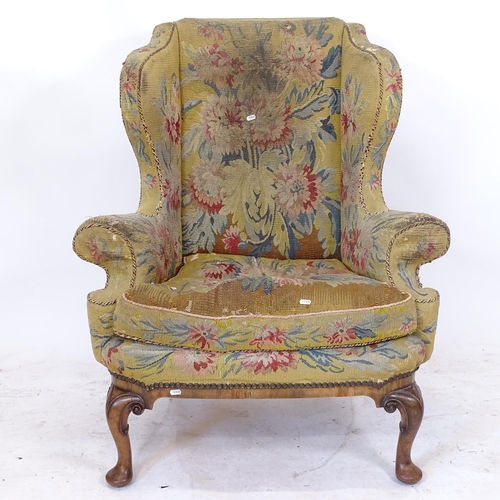 2157 - A George III wing armchair, with needlepoint upholstery, on walnut cabriole legs