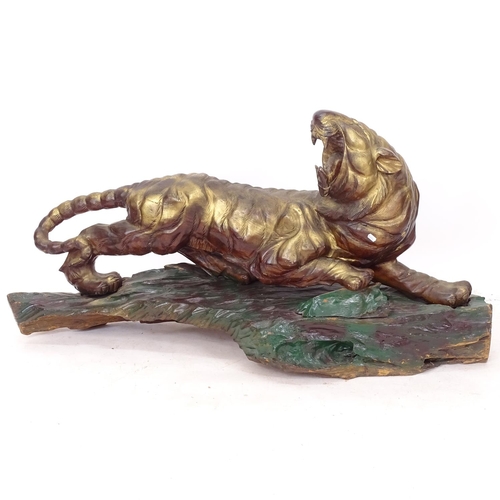 2259 - A large painted and gilded tiger, on naturalistic plinth, L140cm, H75cm