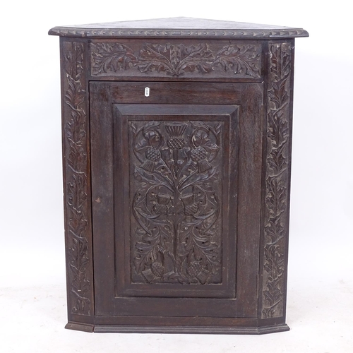 2315 - A Victorian carved oak corner cupboard, with a thistle carved panelled door, W74cm, H92cm