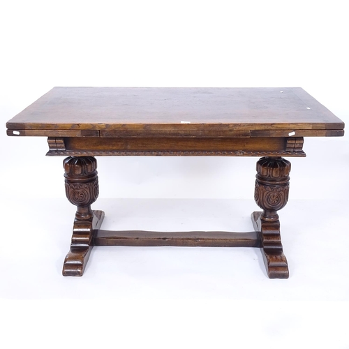 2193 - A rectangular oak draw leaf dining table, with carved frieze, baluster carved legs and flat stretche... 