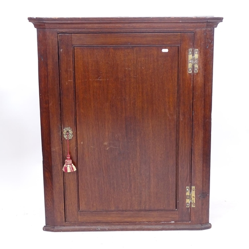 2221 - A Georgian oak hanging corner cupboard, with single panelled door, W78cm, H96cm