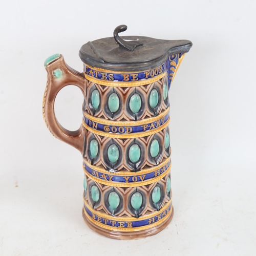 241 - A Wedgwood Majolica pottery jug, with pewter lid and relief moulded motto, height 21cm