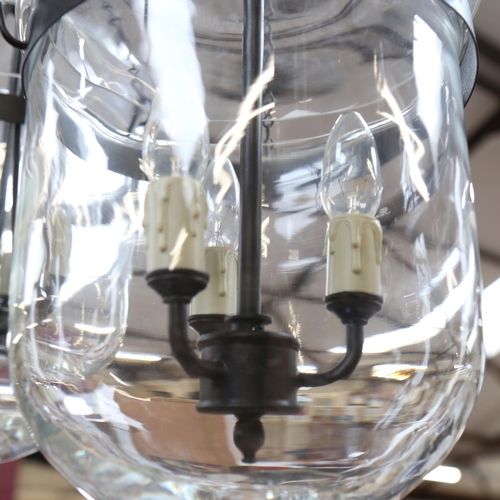 495 - A pair of hanging glass light fittings, with wrought-metal mounts, diameter 22cm