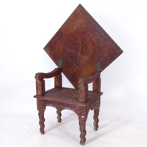 2001 - An Anglo-Indian ornately carved metamorphic table, the top tilting to form a chair with peacock back... 