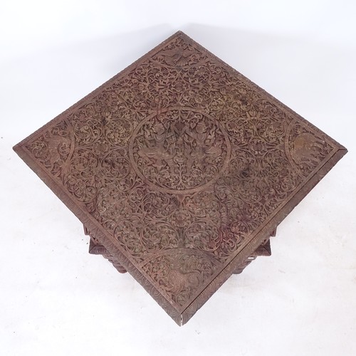 2001 - An Anglo-Indian ornately carved metamorphic table, the top tilting to form a chair with peacock back... 