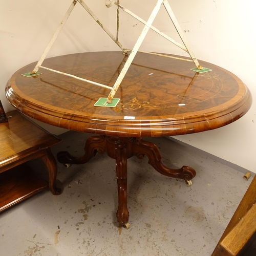 2727 - A Victorian figured walnut oval loo table, raised on a fluted centre column and sabre leg base