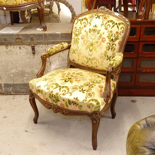 2741 - A French carved framed and floral upholstered open-arm chair