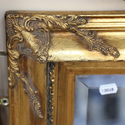 781 - A bevel-edge wall mirror in ornate gilt-frame, height 80cm