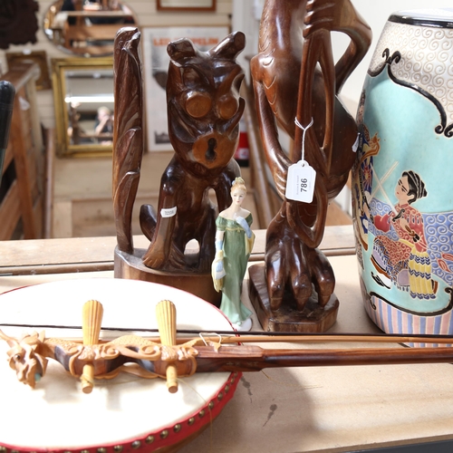 786 - A ceramic barrel garden seat, carved figures, musical instruments, cases, various fabric etc