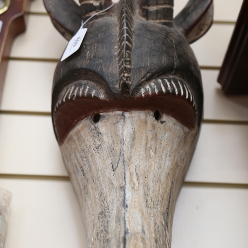 784 - A carved and painted Tribal wall mask, modelled as the head of a antelope, height 70cm