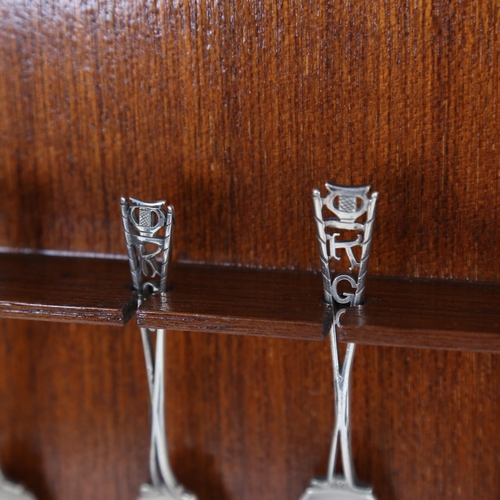 1030 - A framed set of 6 Elizabeth II silver golf teaspoons for the Kumasi Ghana golf club, openwork handle... 