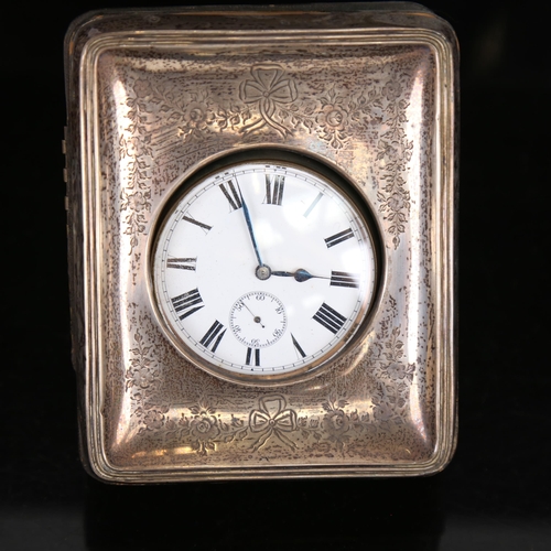 1059 - An Edwardian silver-fronted leather travelling Goliath timepiece, with strut backing and engraved Ad... 