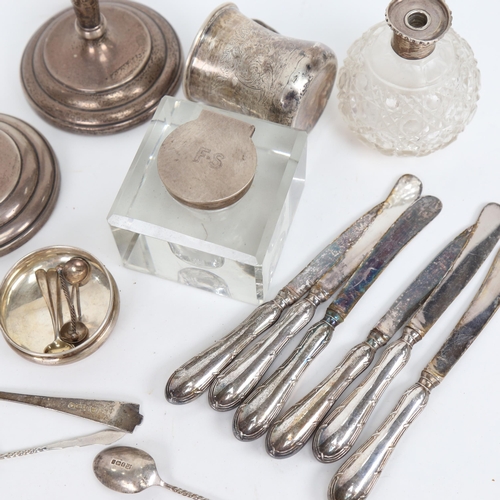 866 - A box of silverware, to include a pair of candlesticks, a christening mug, a silver-mounted inkwell,... 