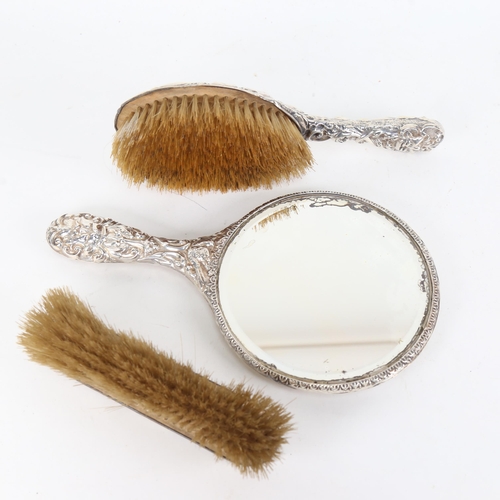 884 - An Art Nouveau 3-piece silver dressing table brush and mirror set, with allover embossed decoration