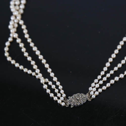 983 - A triple-strand imitation pearl necklace, with a sterling silver and marcasite set clasp